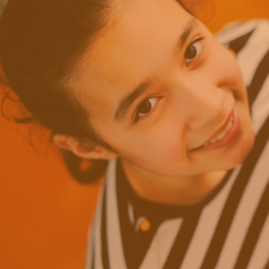 A girl in a striped shirt smiles. Click to access the Gifted or 2e Resource Guide.